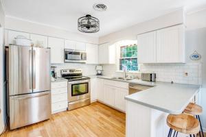 a kitchen with white cabinets and a stainless steel refrigerator at The Seashell Cottage in Ocean City