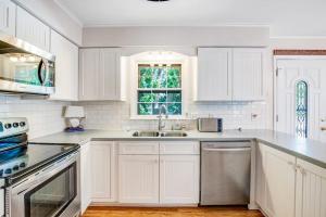 a white kitchen with a sink and a window at The Seashell Cottage in Ocean City