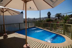 - Piscina con 2 sombrillas en el balcón en Altomiramar, en El Quisco