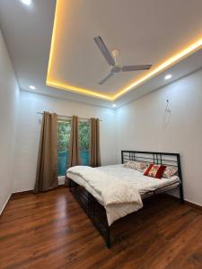 a bedroom with a bed with a ceiling fan at Luxurious Farm in Greater Noida +53 photos