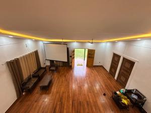 an empty room with a projection screen and wooden floors at Luxurious Farm in Greater Noida