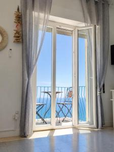 a room with a sliding glass door with a view of the ocean at CasaAzul in Sperlonga