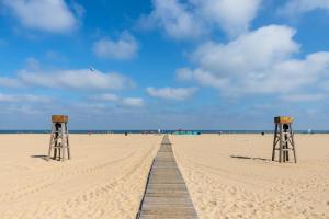 a wooden boardwalk on a beach with a blue sky at White Marlin 209B in Ocean City