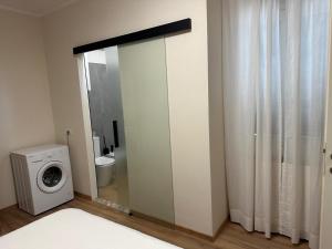 a bathroom with a washing machine and a toilet at Salsedine house in Punta Marina