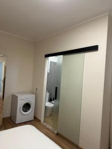 a bathroom with a washing machine and a toilet at Salsedine house in Punta Marina