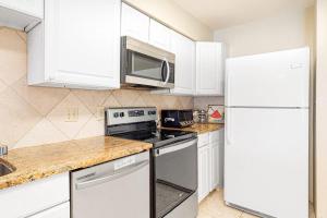 a kitchen with white cabinets and a white refrigerator at Sunset Harbour B in Ocean City