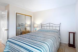 a bedroom with a large bed and a mirror at Sunset Harbour B in Ocean City