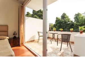 a room with a patio with a table and chairs at Amidst Monuments and Serenity in New Delhi