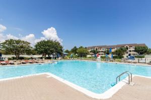 a large swimming pool in a resort with chairs at Heron Haven in Ocean City