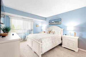 a bedroom with a white bed and blue walls at Heron Haven in Ocean City