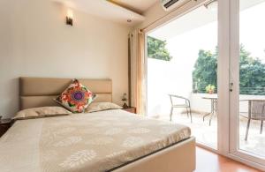 a bedroom with a bed and a sliding glass door at Amidst Monuments and Serenity in New Delhi