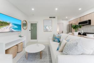 a white living room with a white couch and a table at Casa Luz - Sunlit Boca Pool Retreat in Boca Raton