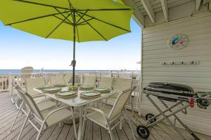 a table and chairs on a deck with an umbrella at Beach Village 6 in Ocean City