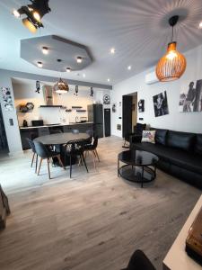a living room with a black couch and a table at AniCa IV De Cine in Tomelloso
