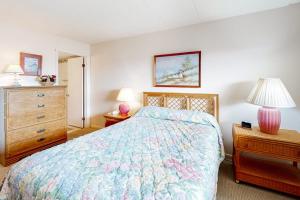 a bedroom with a bed and a dresser and lamp at Sunny Sands 401 in Ocean City +7 photos