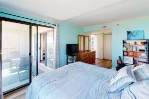 a bedroom with a large bed and a balcony at Waikiki 102 in Ocean City