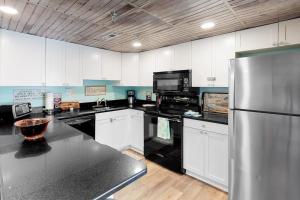 a kitchen with white cabinets and a stainless steel refrigerator at Waikiki 102 in Ocean City +12 photos