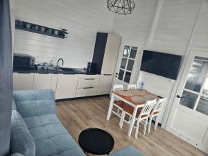 a living room with a blue couch and a table at Domki Letniskowe Do-Iwi in Ustronie Morskie