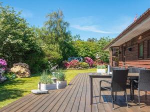 a wooden deck with chairs and a table in a yard at 4 star holiday home in Ulfborg in Ulfborg