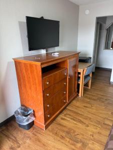 a wooden dresser with a television on top of it at Regency Inn in Muskogee