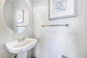 a white bathroom with a sink and a mirror at 13009 Bowline Ln 1 in Ocean City +25 photos