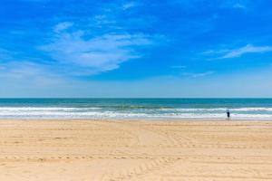 a person standing on a sandy beach near the ocean at Constellation House 107 in Ocean City