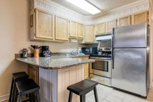 a kitchen with wooden cabinets and a stainless steel refrigerator at Constellation House 107 in Ocean City