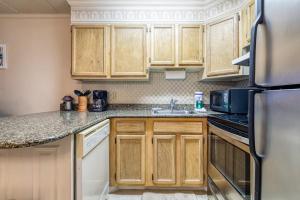 a kitchen with wooden cabinets and a sink at Constellation House 107 in Ocean City
