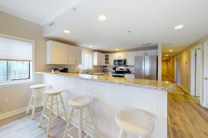 a kitchen with a bar with stools in it at Avalon 406 in Ocean City
