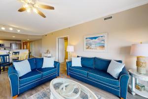 a living room with blue couches and a dining room at Avalon 406 in Ocean City
