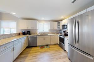 a kitchen with white cabinets and stainless steel appliances at Avalon 406 in Ocean City +17 photos