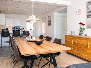 a kitchen and dining room with a wooden table and chairs at 5 star holiday home in Ringkøbing in Ringkøbing