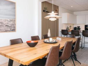 a dining room with a wooden table and chairs at 5 star holiday home in Ringkøbing in Ringkøbing