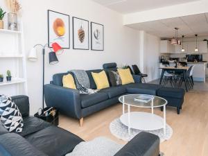 a living room with a blue couch and a table at 5 star holiday home in Ringkøbing in Ringkøbing