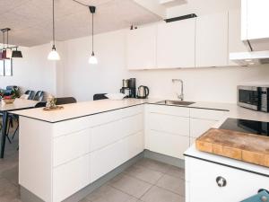 a white kitchen with white cabinets and a sink at 5 star holiday home in Ringkøbing in Ringkøbing