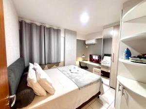 a hotel room with a bed and a television at Apartamentos Renovatio Jatiuca - Castelo B Temporada in Maceió