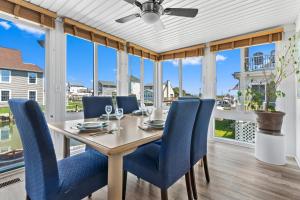 a dining room with a table and blue chairs at Waterfront Home with OC Skyline Views in Ocean City