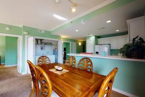 a dining room with a wooden table and a kitchen at Sunset Bay III 313 in Ocean City