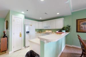 a kitchen with green walls and a white counter top at Sunset Bay III 313 in Ocean City +18 photos