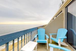 two blue chairs sitting on a balcony overlooking the ocean at Century I 2521 in Ocean City
