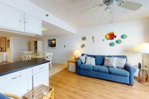 a living room with a blue couch and a kitchen at Century I 2521 in Ocean City +17 photos