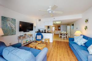 a living room with blue couches and a kitchen at Century I 2521 in Ocean City