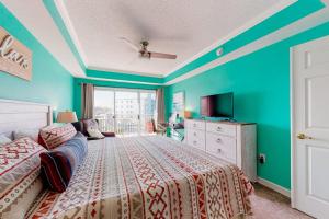 a bedroom with blue walls and a bed and a tv at Bahia Vista II 305 in Ocean City