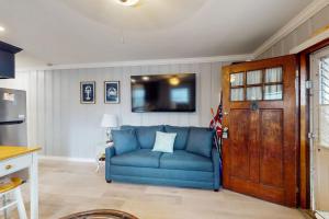 a living room with a blue couch and a tv at Straney #3-Sea Renity in Ocean City