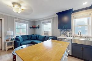 a living room with a blue couch and a kitchen at Straney #3-Sea Renity in Ocean City