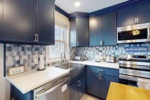 a kitchen with navy blue cabinets and a sink at Straney #3-Sea Renity in Ocean City +18 photos