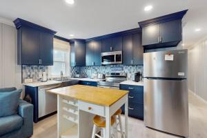 a kitchen with blue cabinets and a wooden counter top at Straney #3-Sea Renity in Ocean City