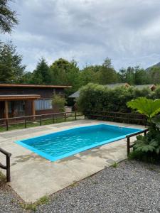 a large blue swimming pool in front of a house at Pichares in Pichare