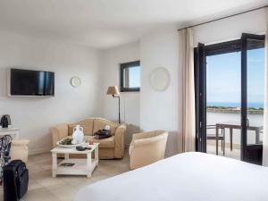 a bedroom with a bed and a living room with a view at Borgobianco Resort & Spa Polignano - MGallery Collection in Polignano a Mare