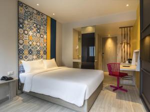 a bedroom with a large white bed and a red chair at Ibis Styles Phuket City in Phuket +103 photos